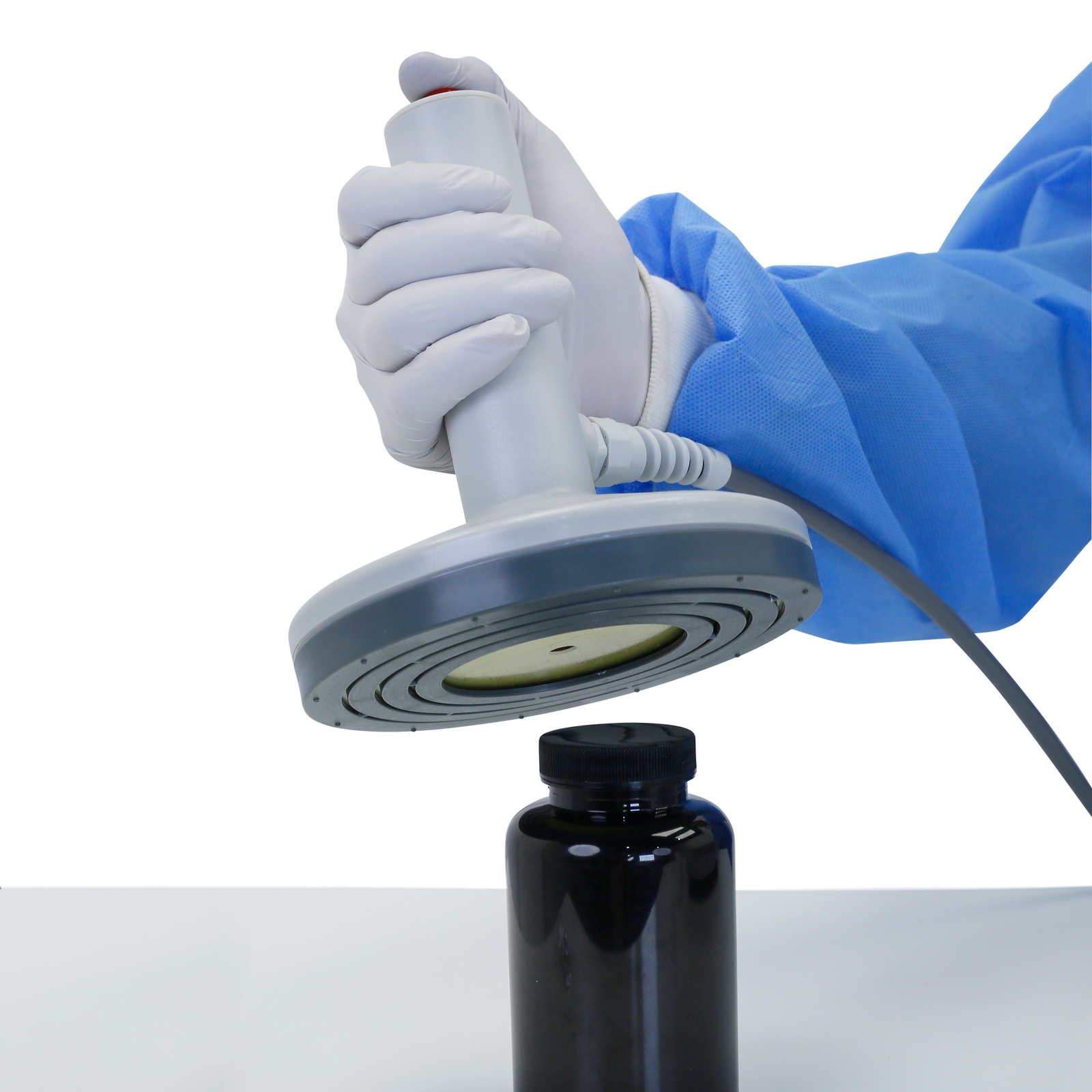 Hand of a person placing the head of the manual induction sealer on top of the plastic cap of a container in order to seal it with an induction liner