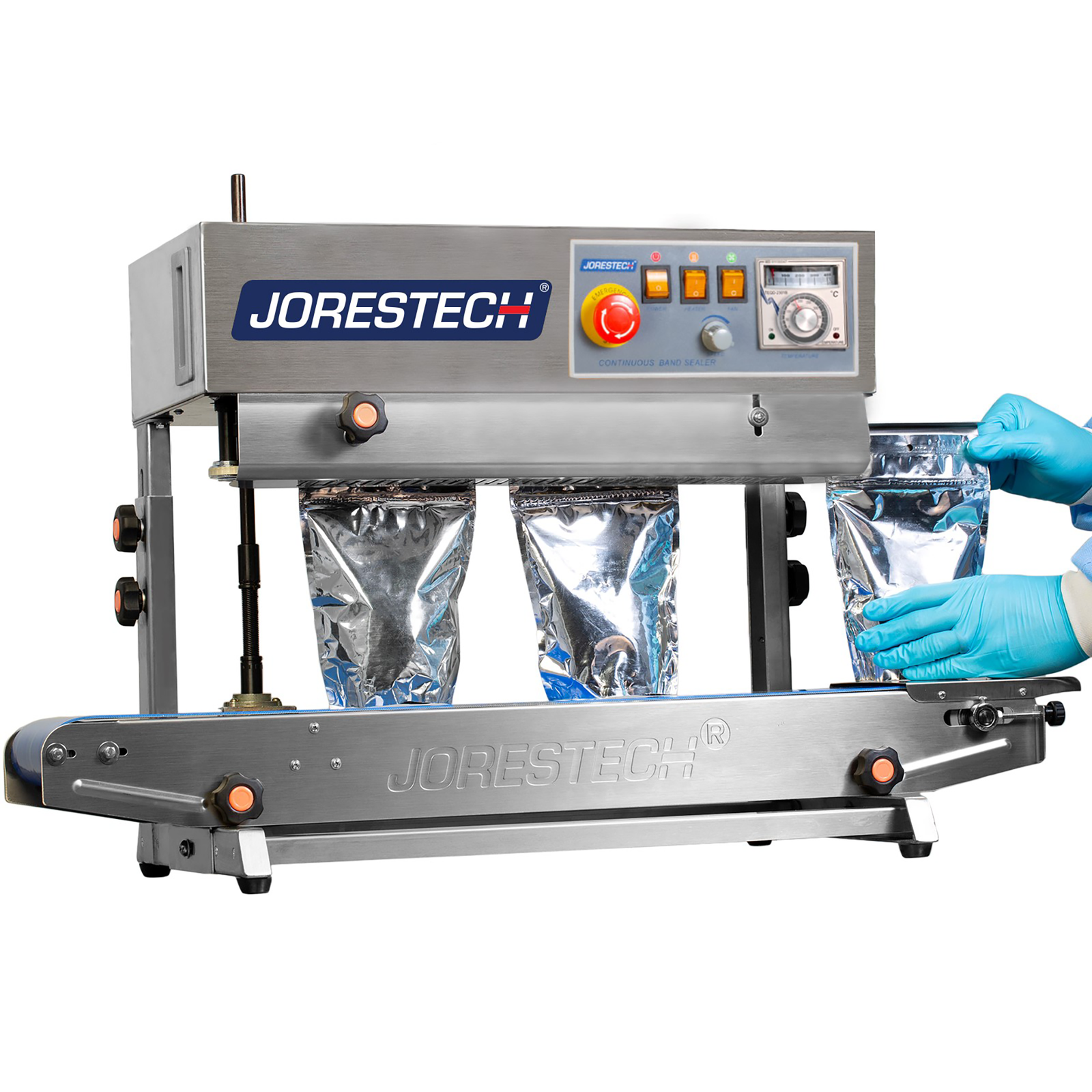 operator wearing blue gloves inserting silver plastic bags in machine to be sealed by a JORESTECH continuous band sealer