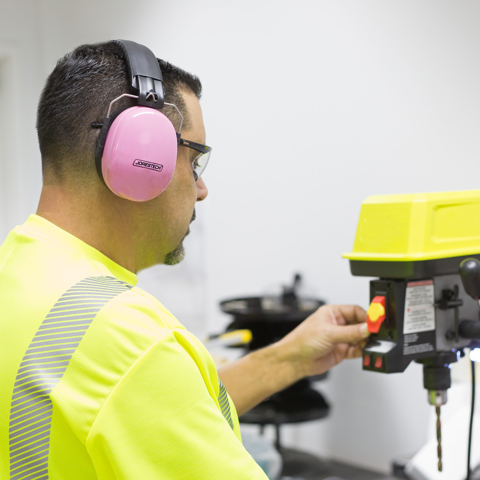 Man using the Noise reduction earmuffs while operation a loud power machine