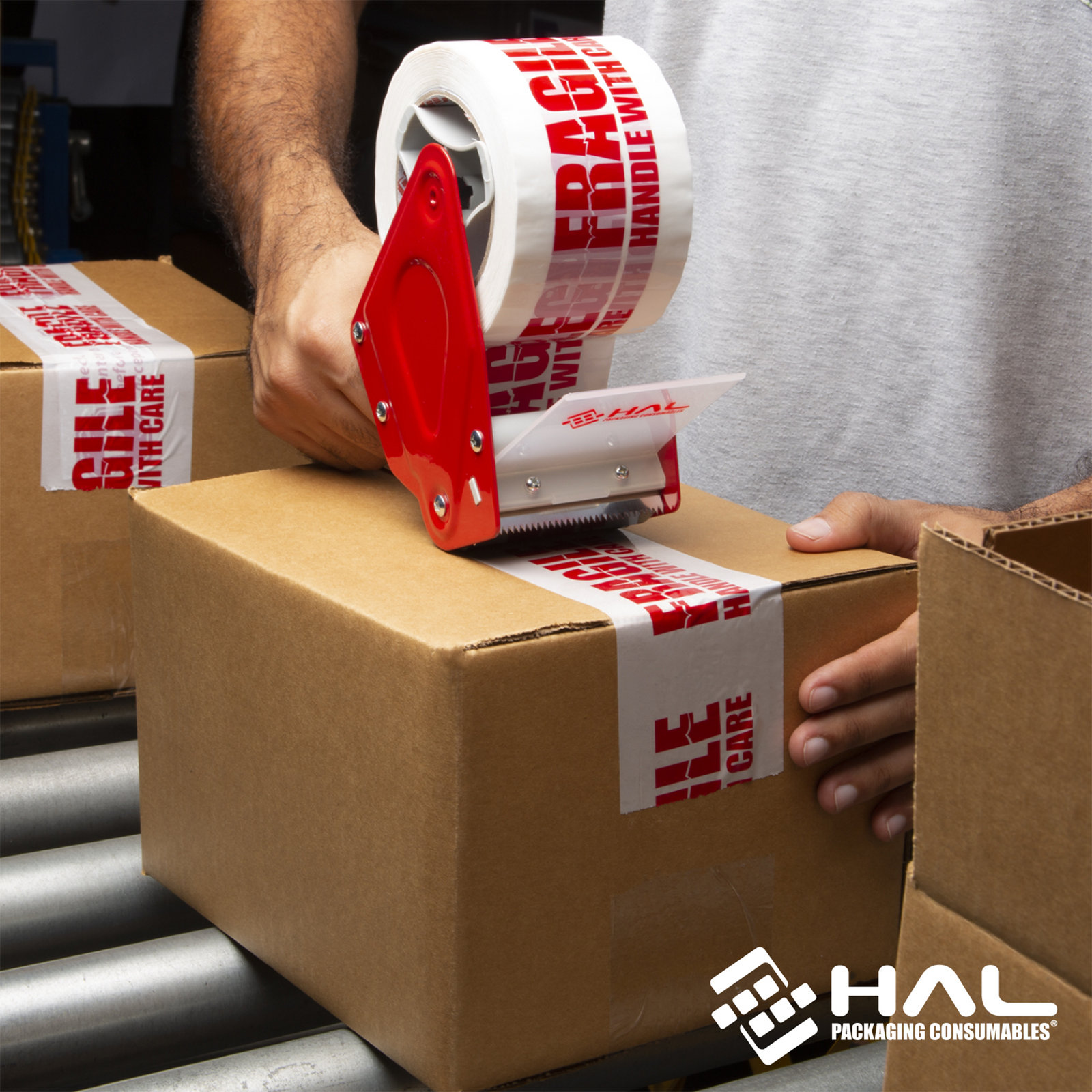 man closing a las=rge number of boxes in a production line using the HAL 3 Inch handheld heavy duty tape dispenser 