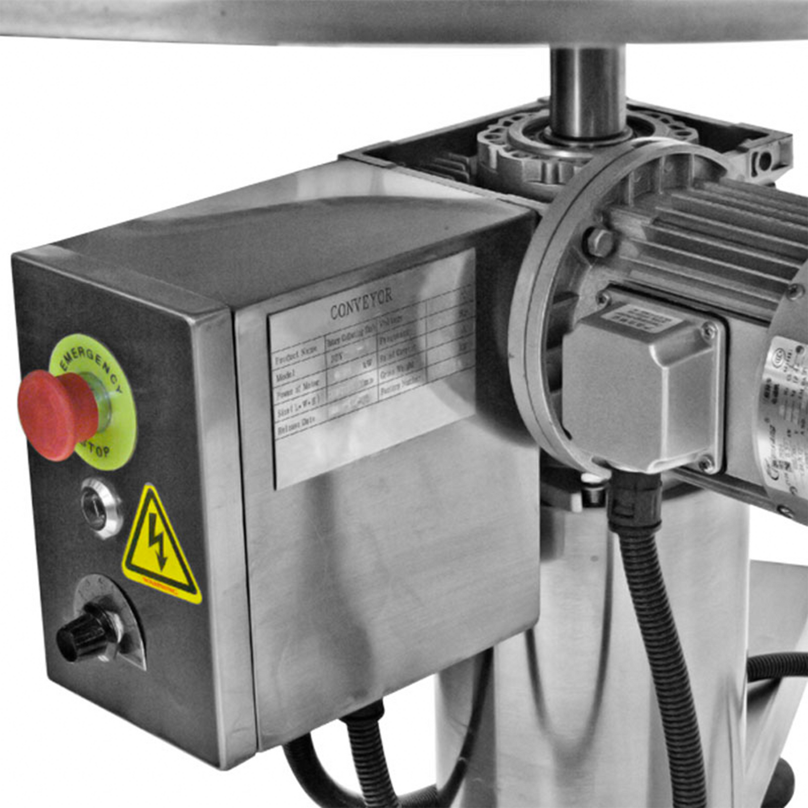close up of stainless steel JORESTECH rotary accumulating table with red emergency stop bottom and yellow warning label
