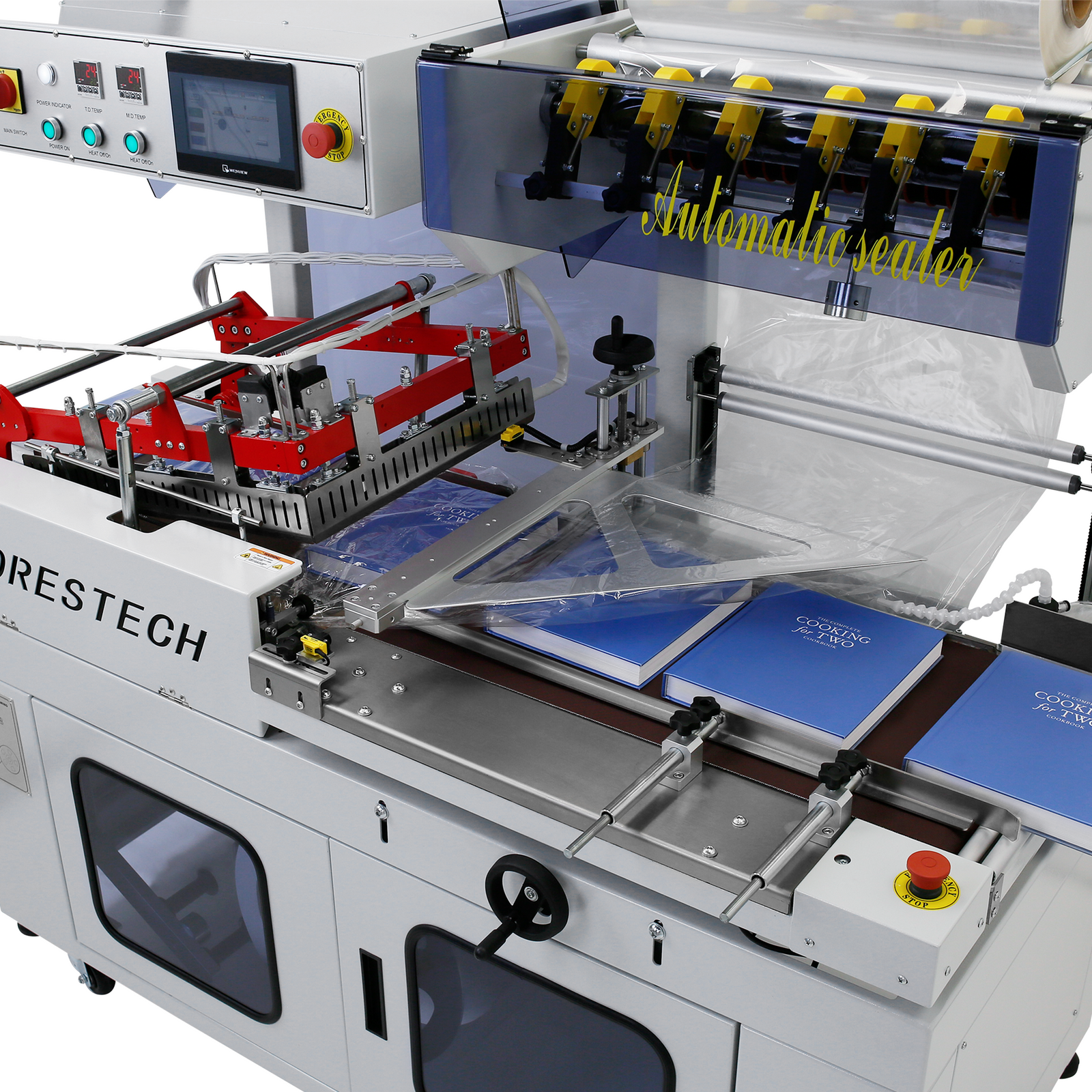 Automatic L Bar Film Sealer under production. There are 4 large books place on top of the motorized conveyor while being sealed with clear plastic. Digital control panel of the Automatic L bag sealer is turned on 