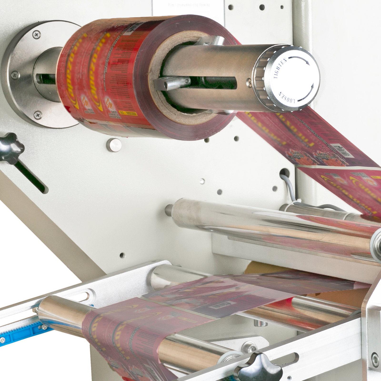 Close up of the film roll holder on a flow wrapping machine, with a red packaging film roll threaded through the easy to use horizontal flow wrapper machine