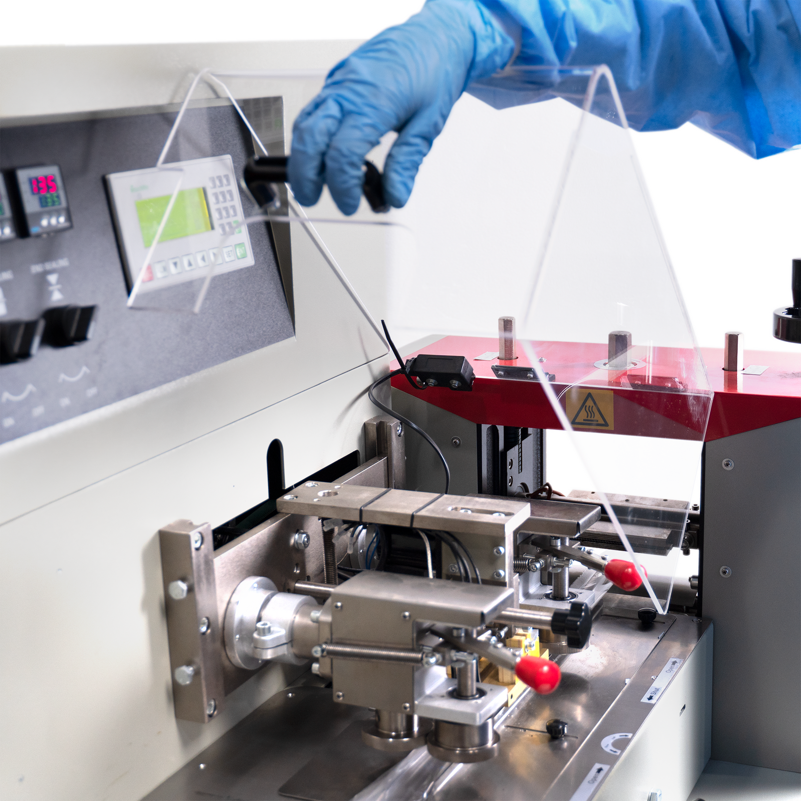 Worker opening the protective cover of the bag form and seal mechanism on an horizontal flow wrapper