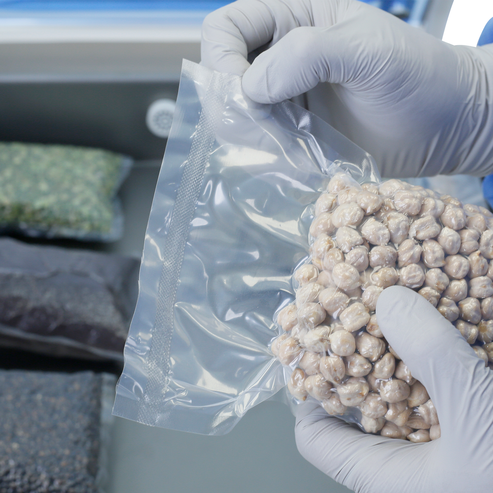 Person wearing nitrile gloves holding a bag with chick peas. He is showing the seal done by a Commercial single chamber JORESTECH vacuum sealer with dual seal bars