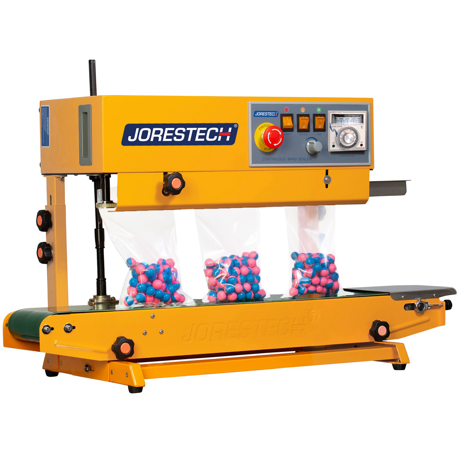 Yellow JORES TECHNOLOGIES® continuous band sealer sealing bags with blue and pink paint balls. The bag sealing machine is set in a vertical position and sealable bags are standing on the conveyor while being sealed 