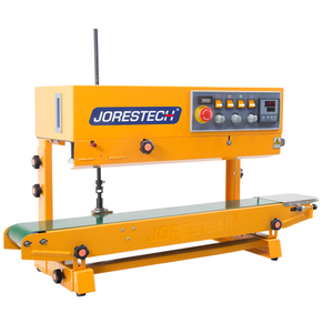 Diagonal view of the yellow JORESTECH horizontal and vertical  continuous band sealer showing the control panel with digital temperature control, the red emergency stop button and other switches.