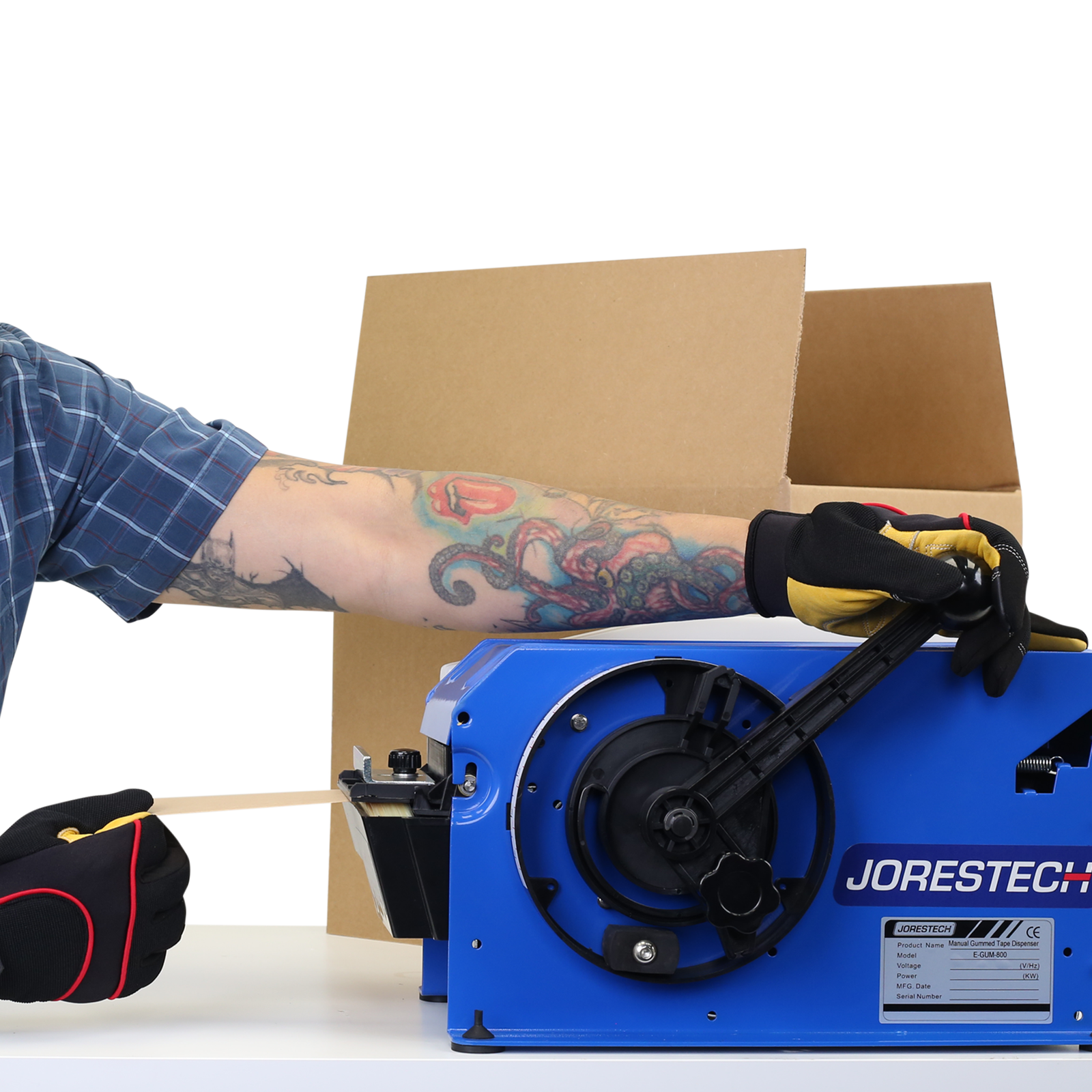 man pulling the black handle on blue JORES TECHNOLOGIES® gummed kraft paper tape dispenser to roll out brown paper kraft tape and place it on an open card box