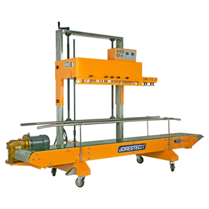 Diagonal view of the yellow heavy duty JORESTECH continuous band sealer with green revolving conveyor band and wheels