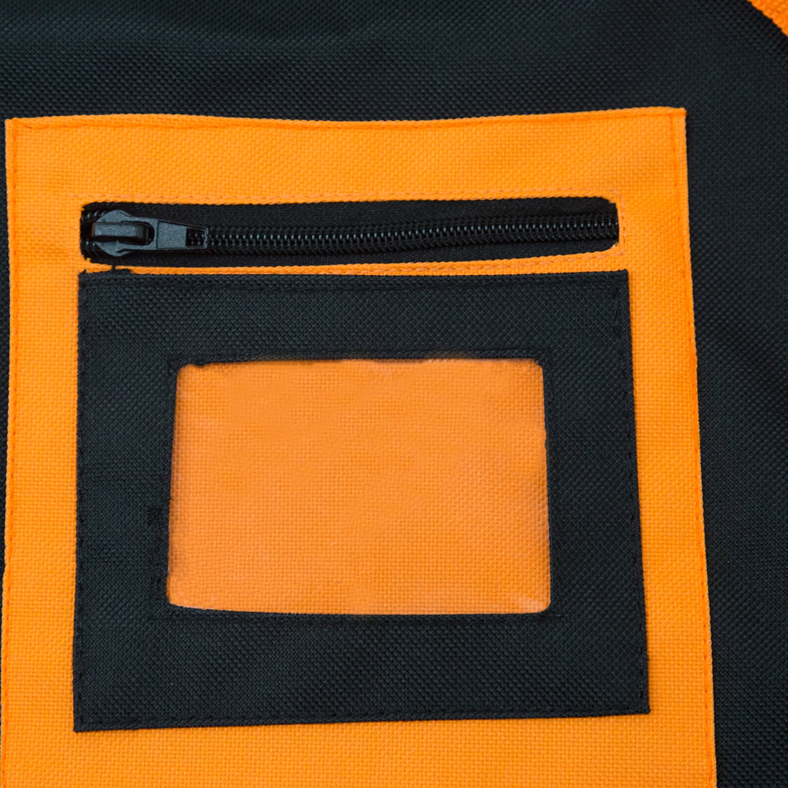 Close up of the PVC transparent pocket to place ID badges on the chest of the black and orange tool vest