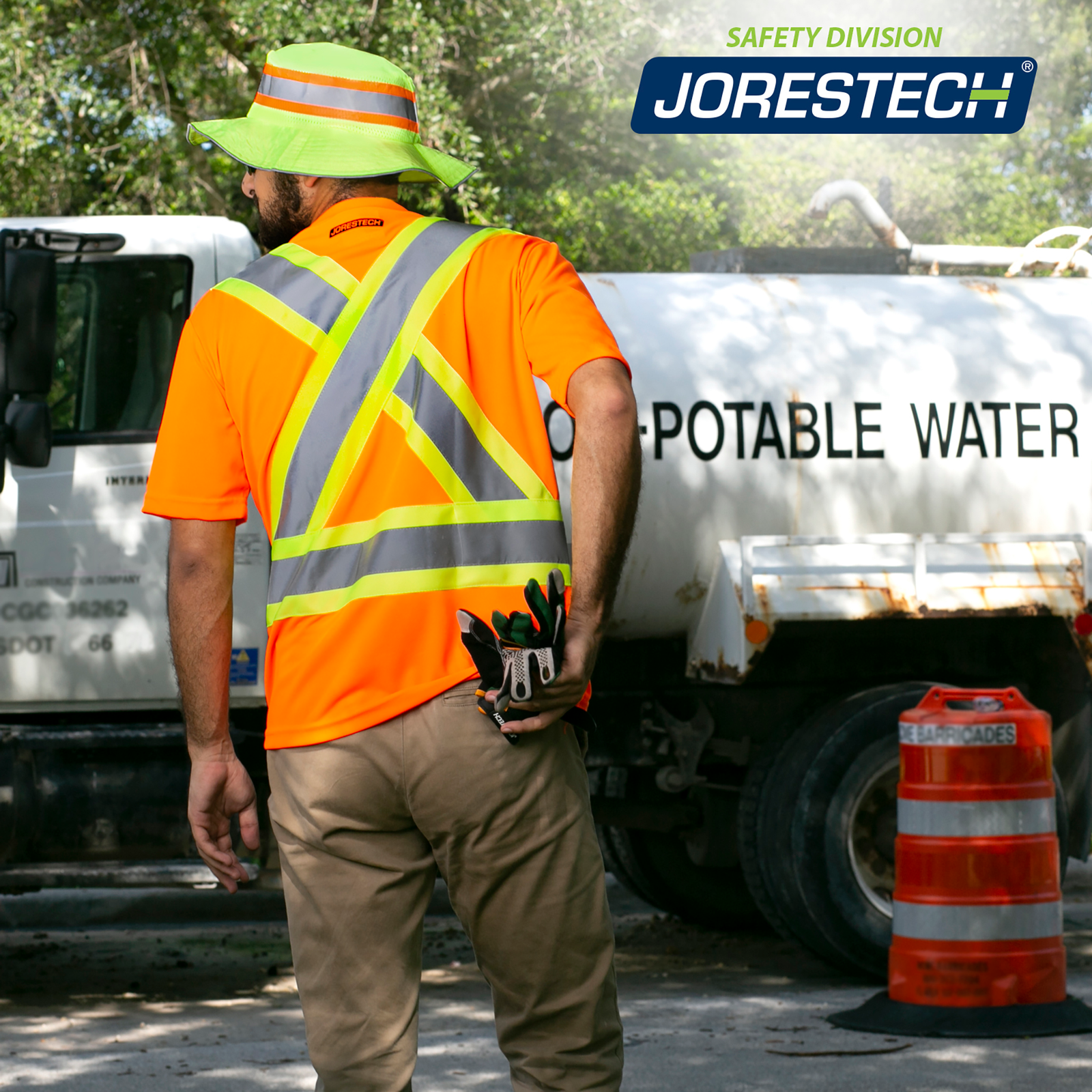 A worker wearing a JORESTECH Orange reflective safety shirt while driving a truck