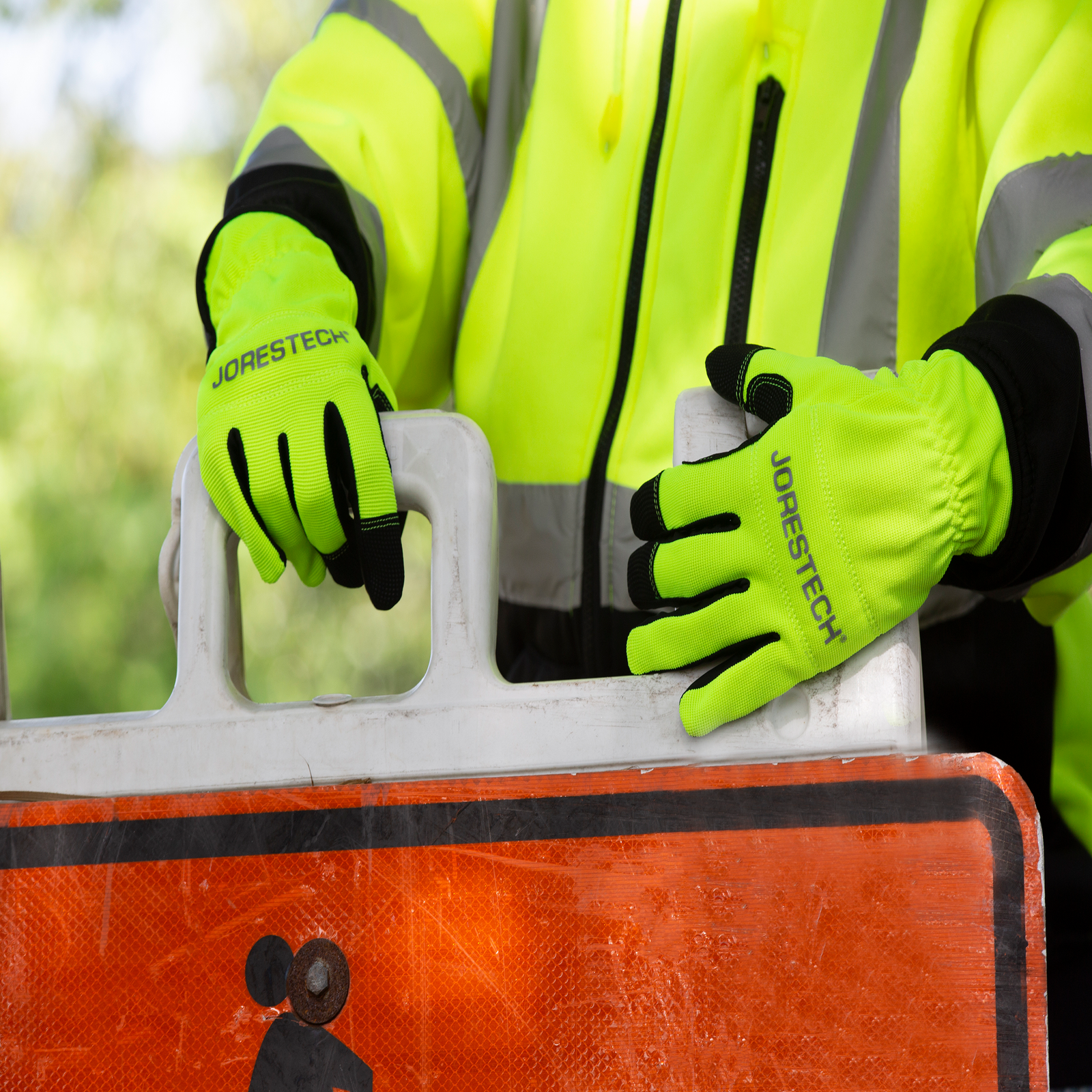 Person wearing safety work gloves color lime for road construction