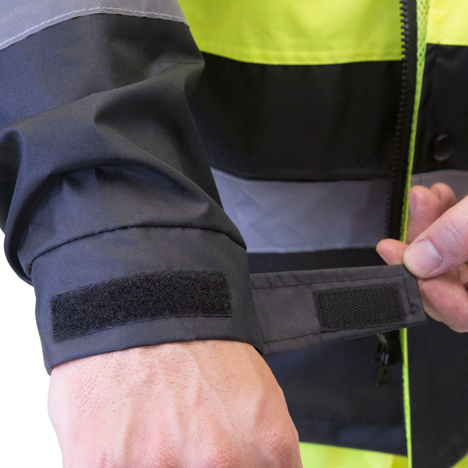 Man closing the strap of the size adjustable cuff the hi vis rain jacket. for road work