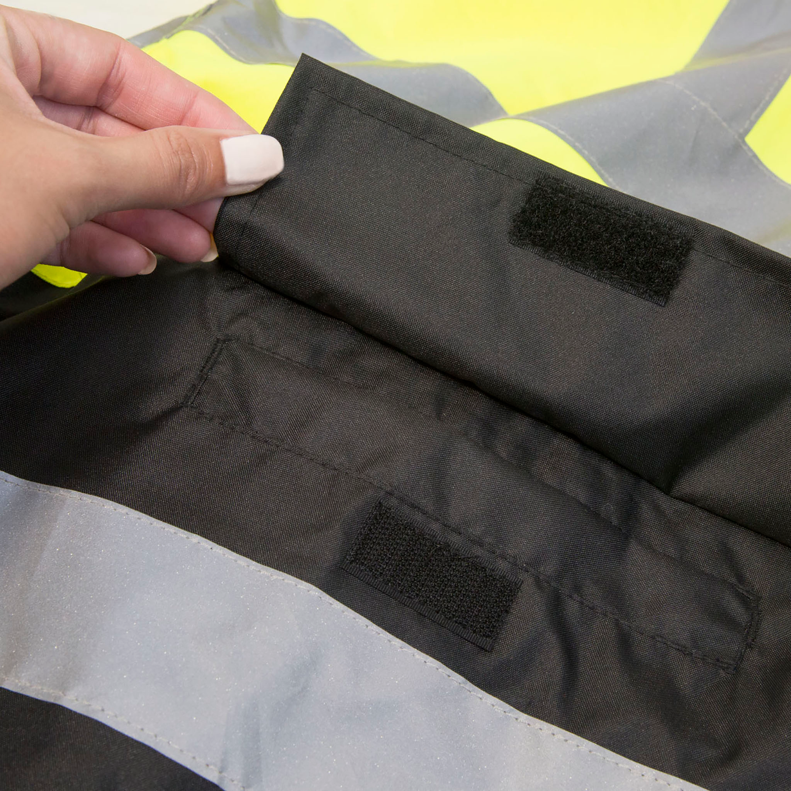 High vis rain jacket with waist pockets and flaps with hook and loop closures for improve rain protection