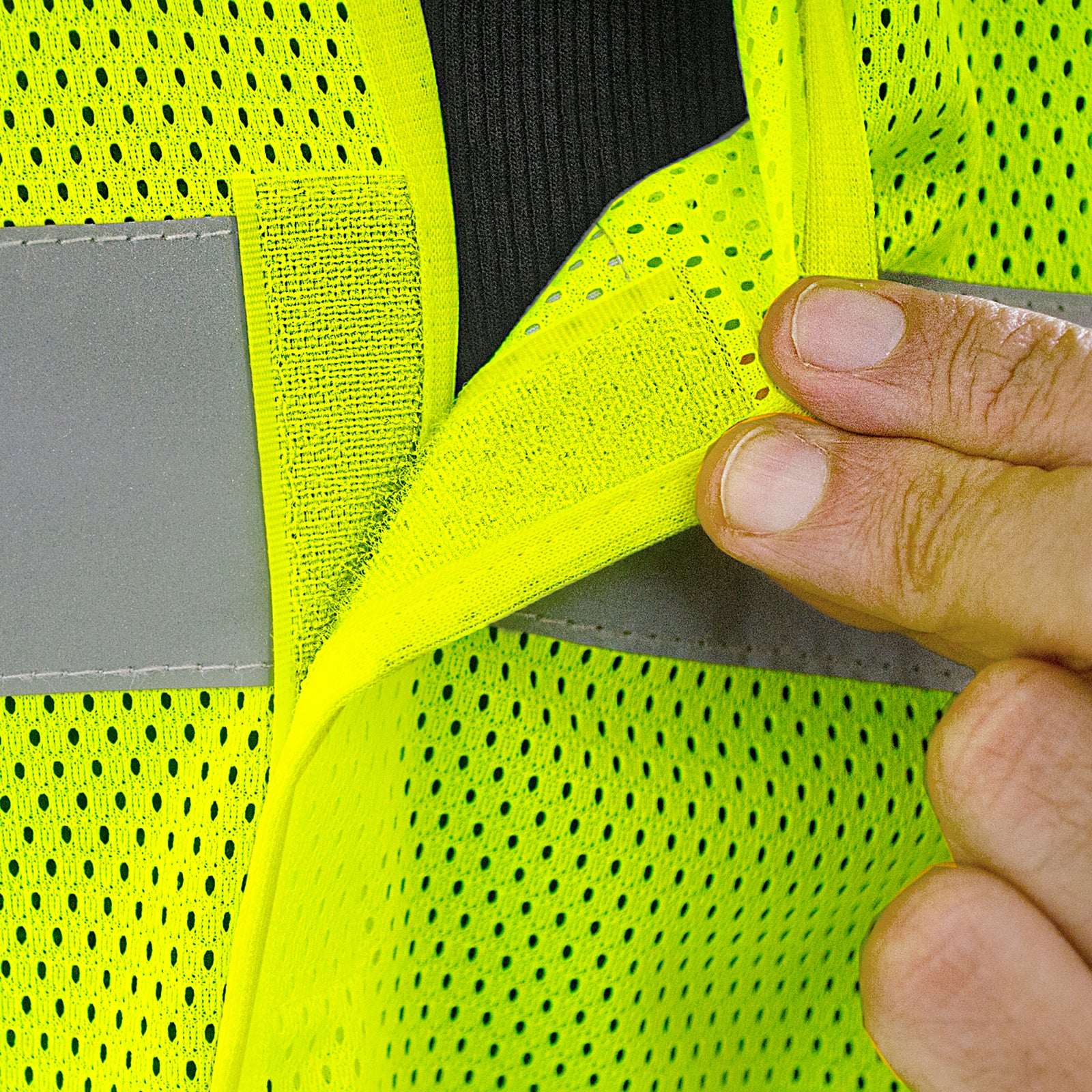 Close-up shows the mesh material and the hook and loop closure of the tearaway reflective safety vest