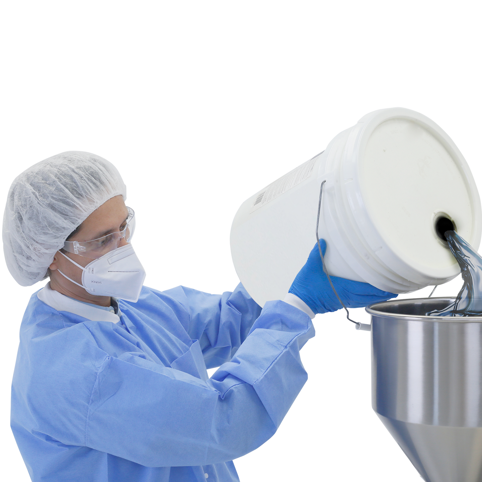 A worker dressed in PPE clothing and nitrile gloves filling up the Hopper of a JORES TECHNOLOGIES® high viscosity tabletop paste piston filler