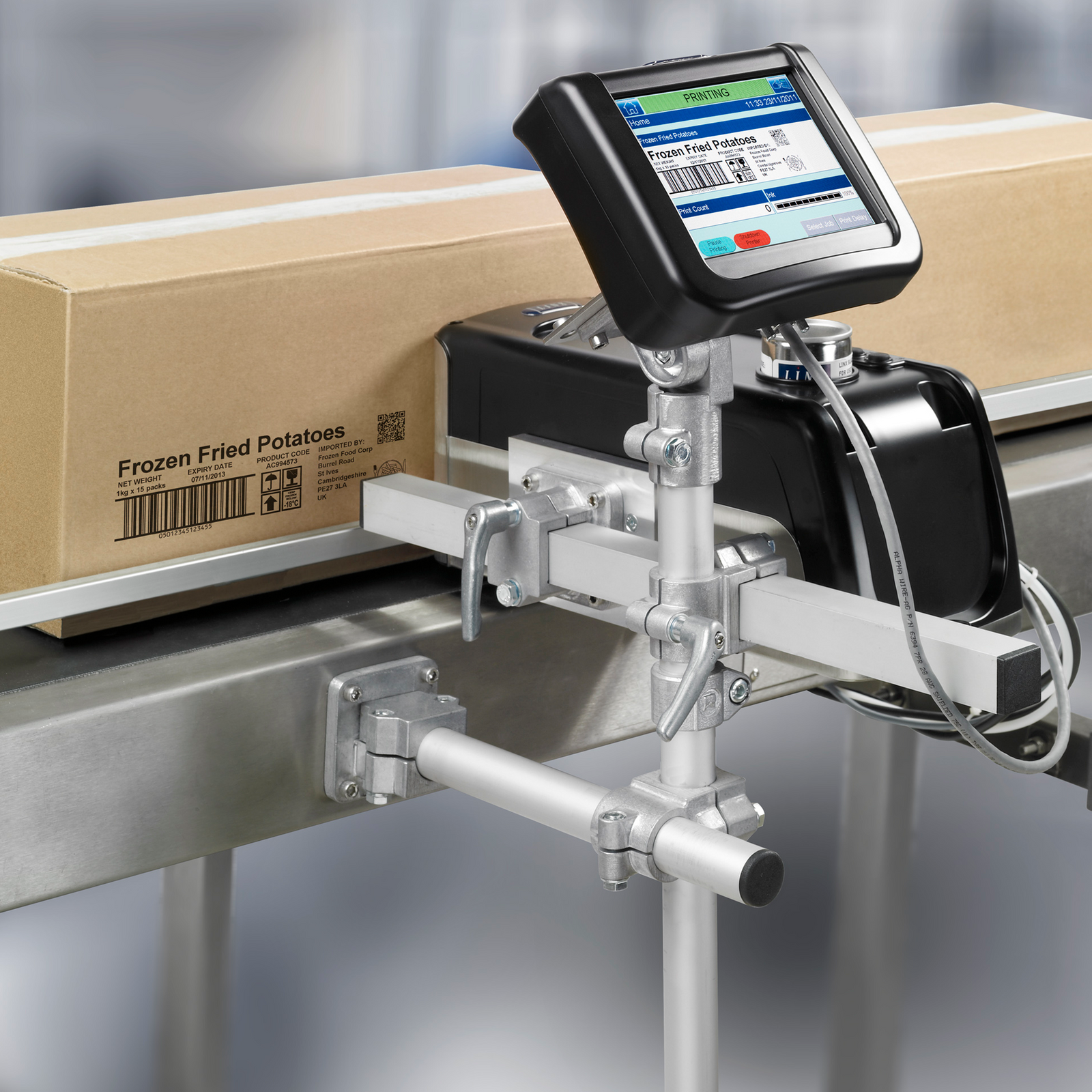 Linx IJ375 Inkjet case coder installed on its base and base attached to a motorized conveyor with card boxes passing by the print head