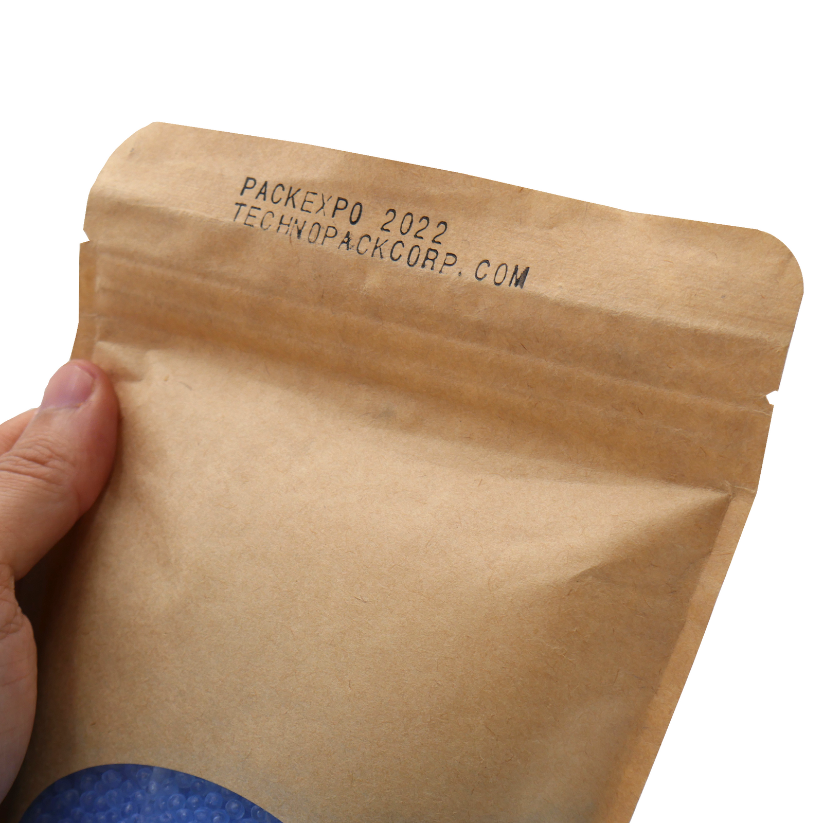 The hand of a person holding a brown bag with a date and a web page printed and sealed by a left to right continuous band sealer with coder