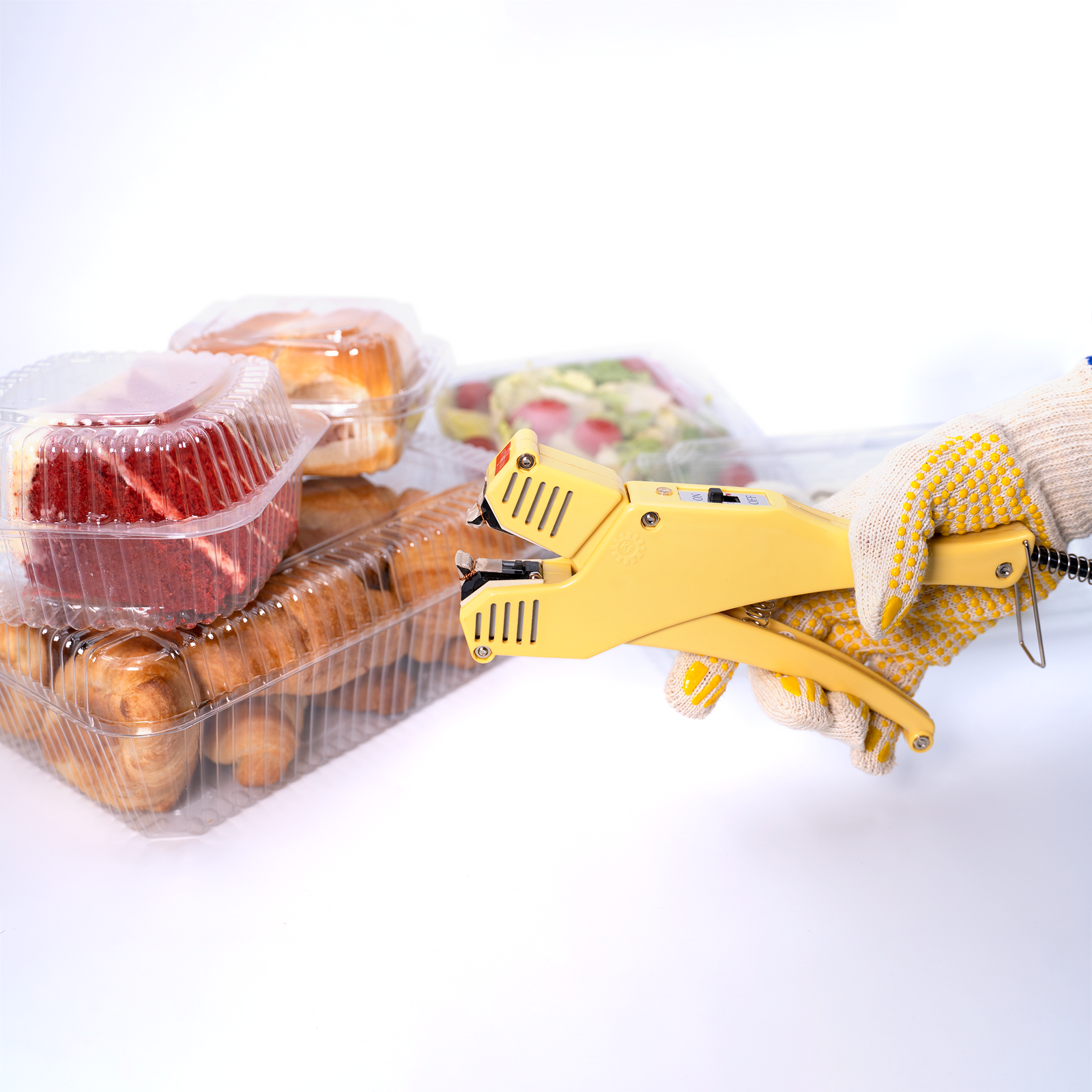 Worker using the JORES TECHNOLOGIES® manual direct heat clamshell sealer to close clear boxes filled with food