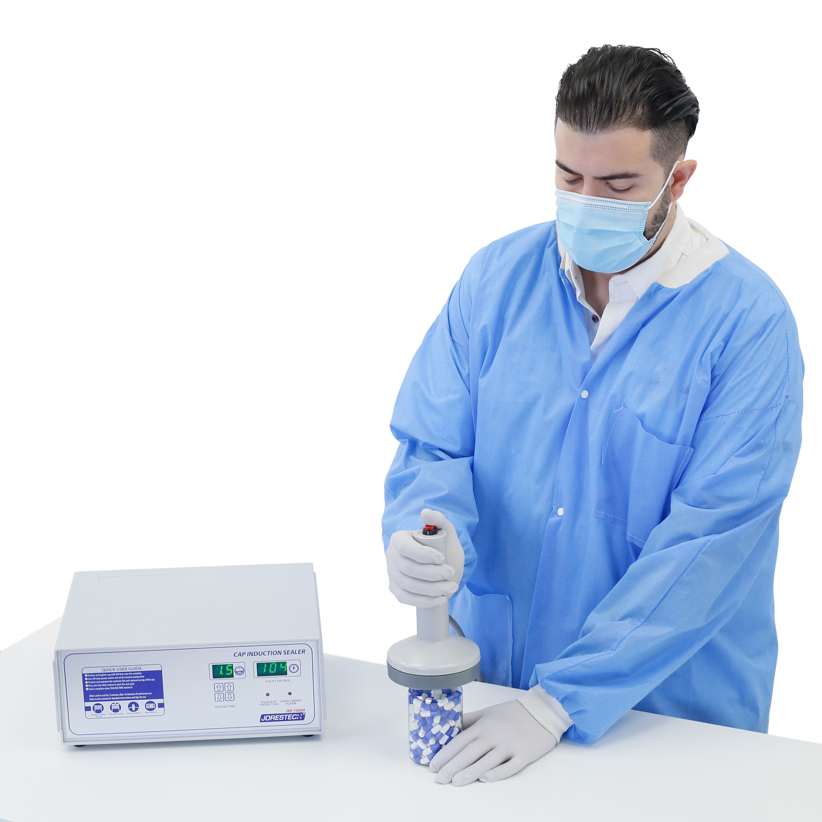 Person in a lab wearing personal protection equipment sealing a bottle of pills using the jorestech induction cap sealer