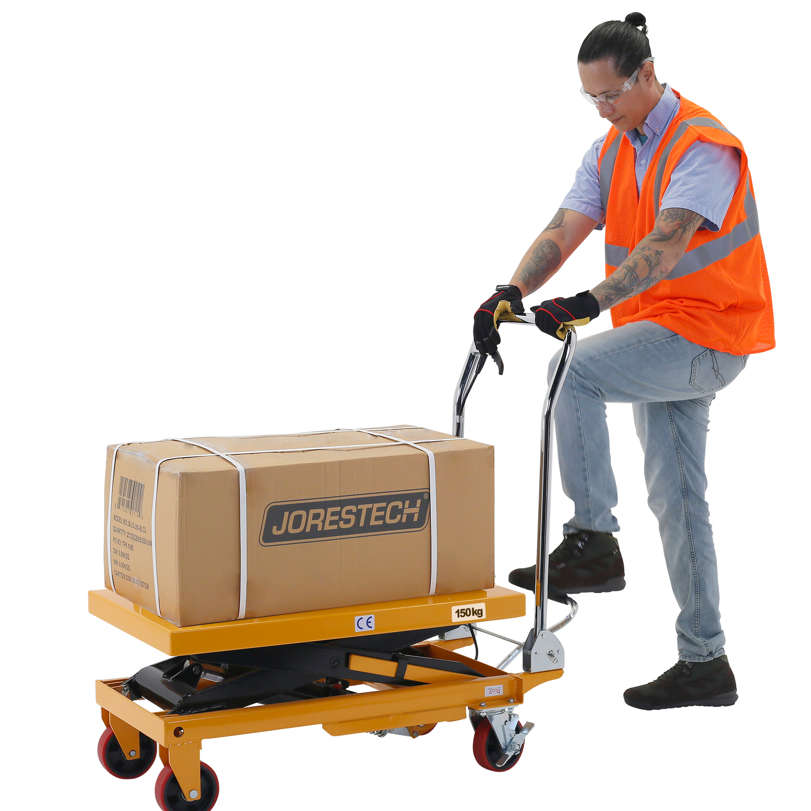 Man wearing an orange high visibility vest pressing the foot pedal of the hydraulic JORES TECHNOLOGIES® scissor lift table to lift a heavy brown box  with ease