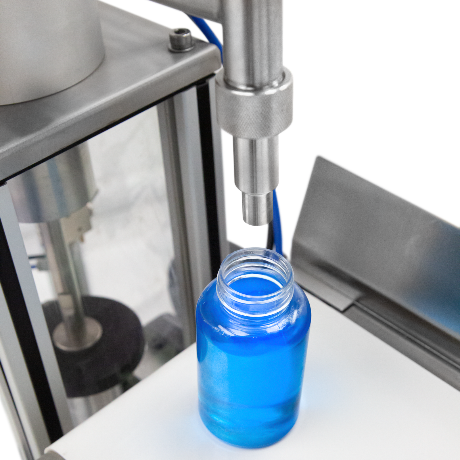 Closeup shows the stainless steel non-drip nozzle over the clear bottle filled with blue high viscosity liquid