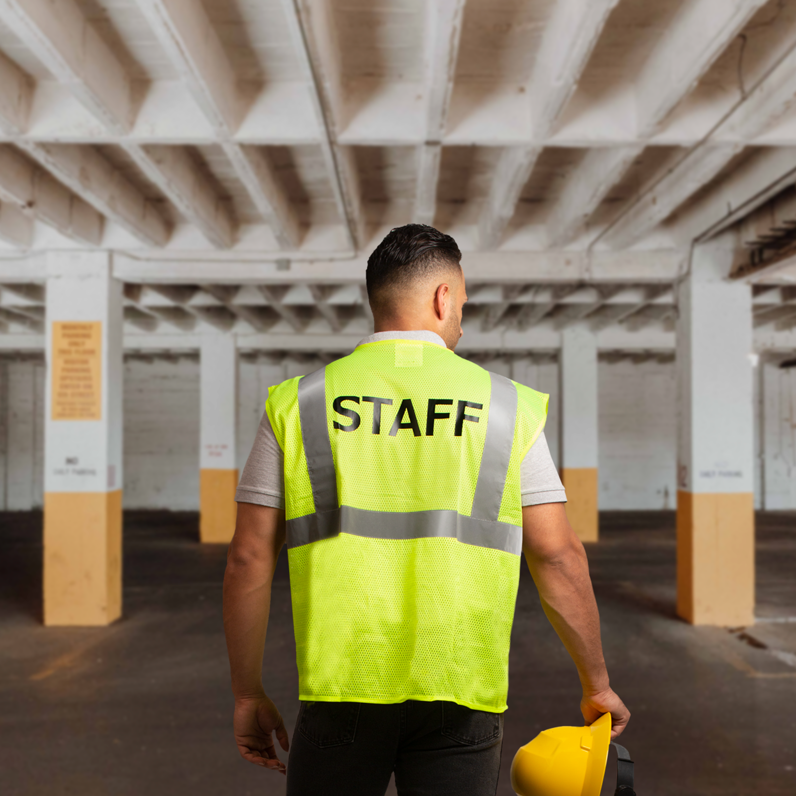 A man wearing a printed lime JORESTECH safety vest with STAFF of the back