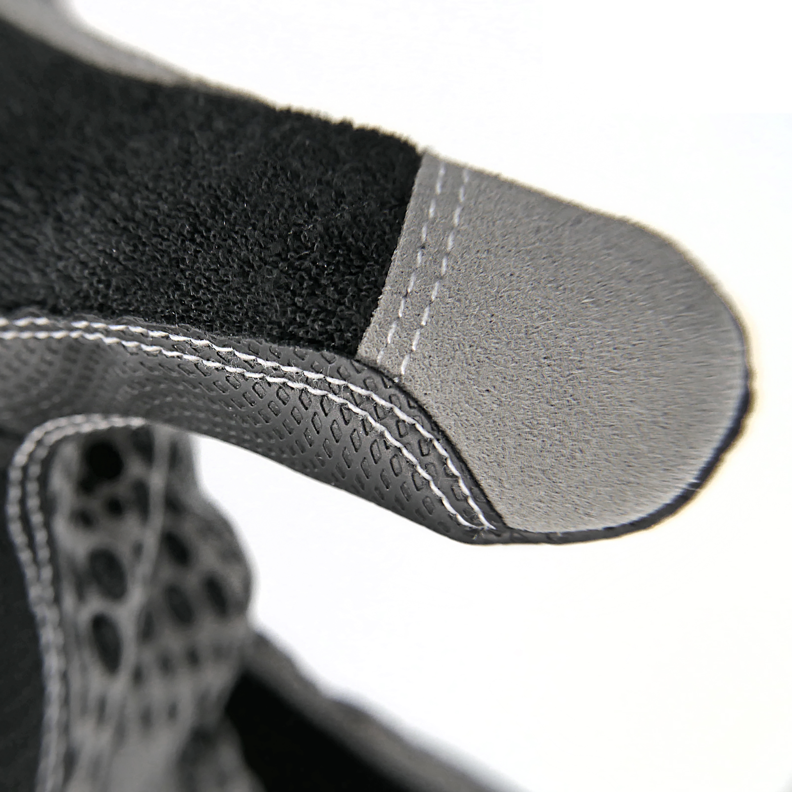 Close up of the fabric of the thumb of the black safety work glove with reinforced finger tips