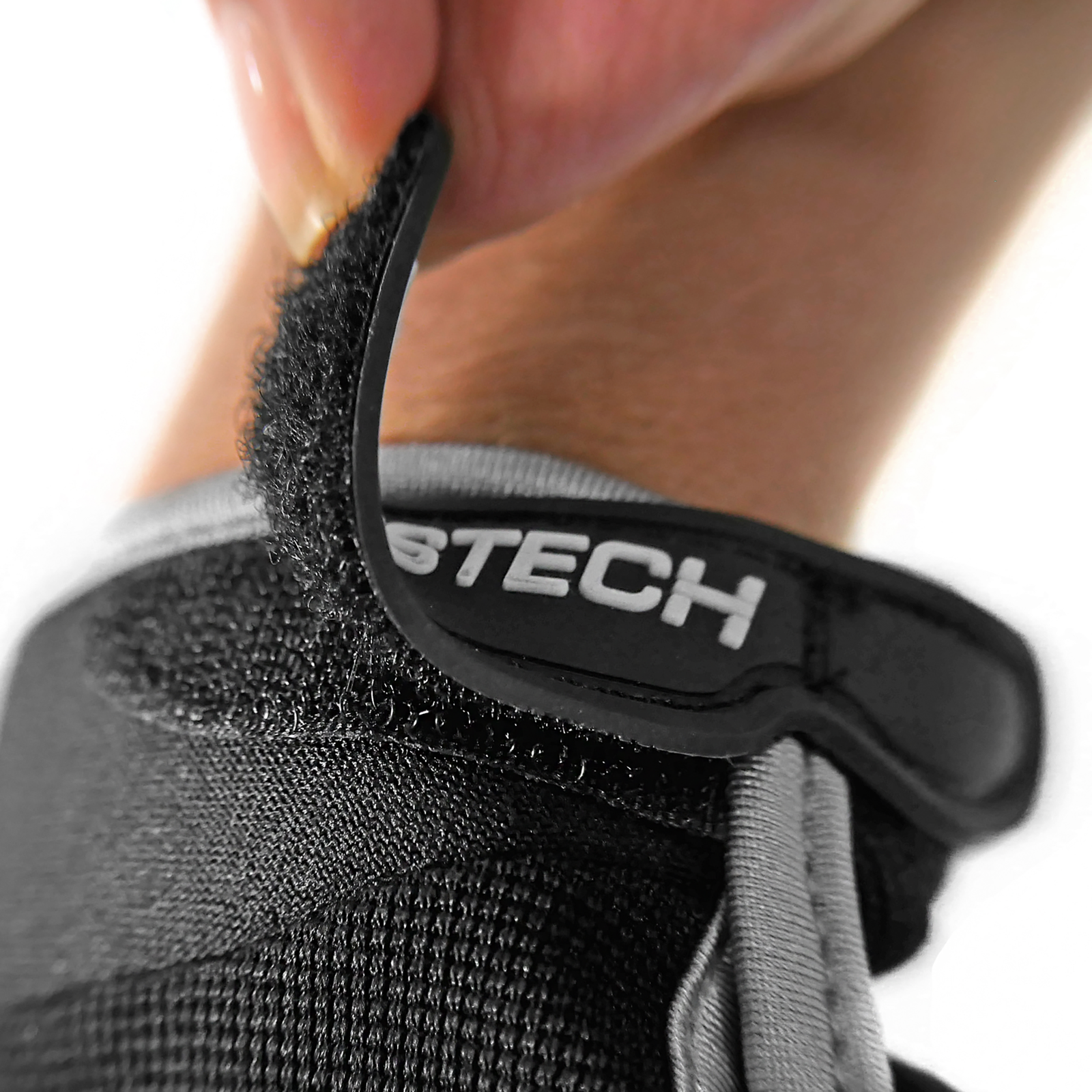 Close up of the hook and loop closure system of the black JORESTECH safety work glove with anti slip silicone black dotted palms
