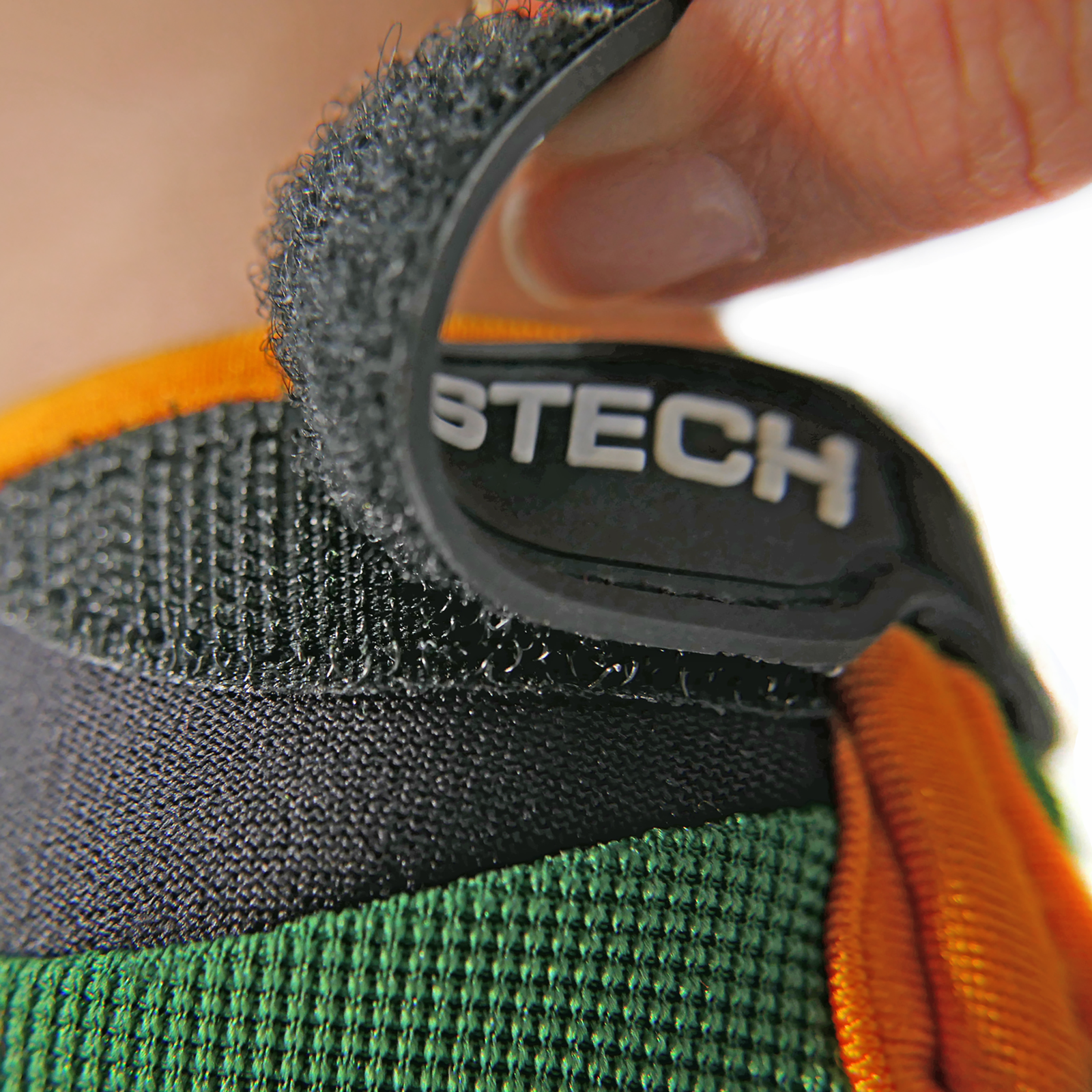 Close up of the hook and loop closure system of the green JORESTECH safety work glove with anti slip silicone black dotted palms