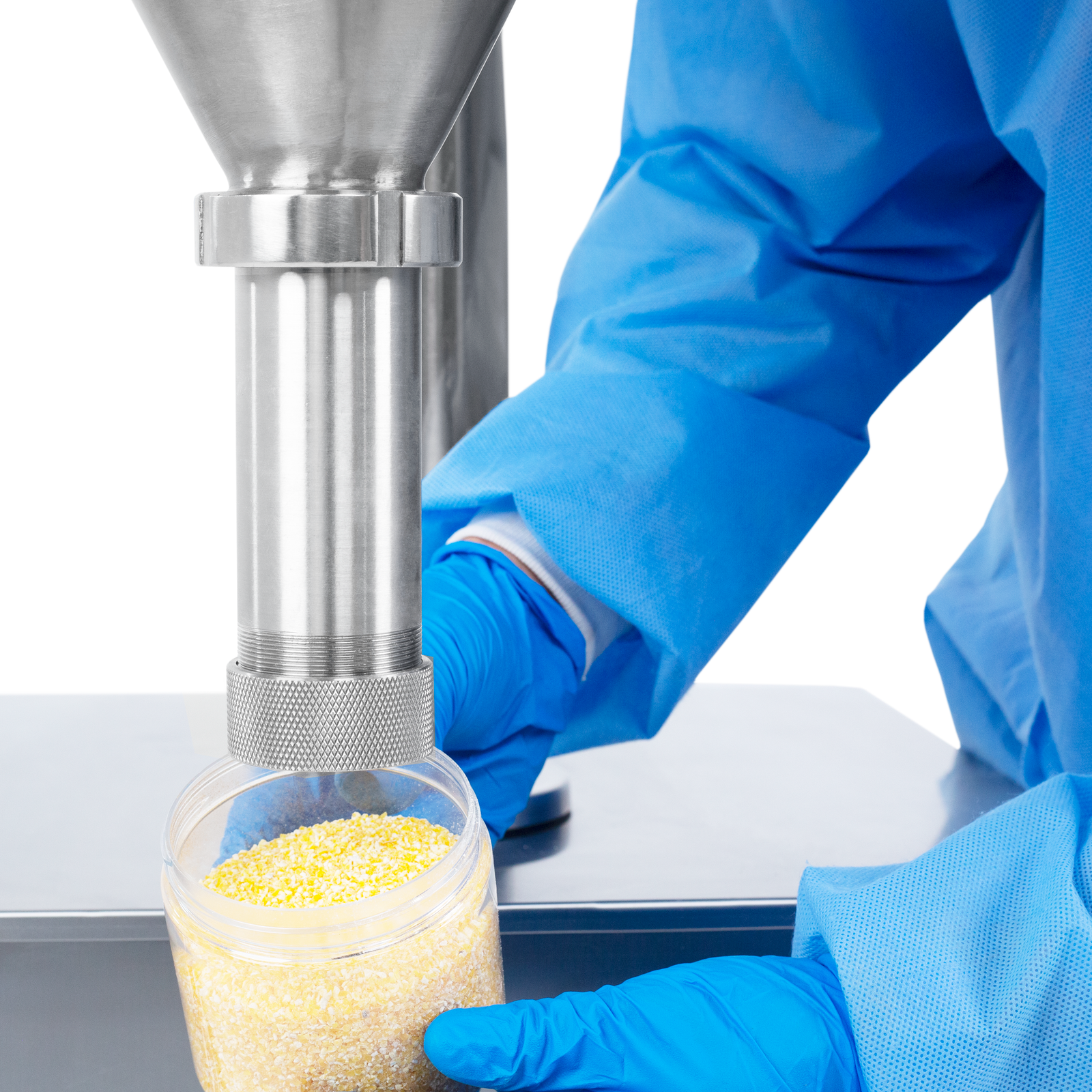 Close-up of the hands of a person with blue latex gloves and PPE holding a clear container filled with cornmeal flour. The container is held under the dispensing nozzle of an auger powder filler, which was used to the powder into the container