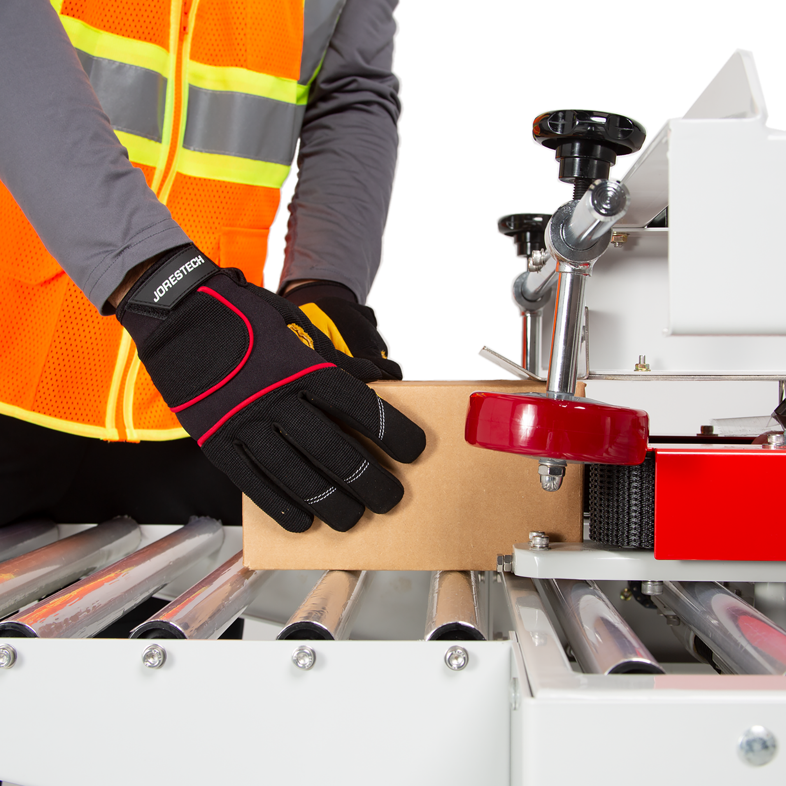 operator wearing black gloves and orange safety vest  inserting small brown box in the track of the case sealer with side traction