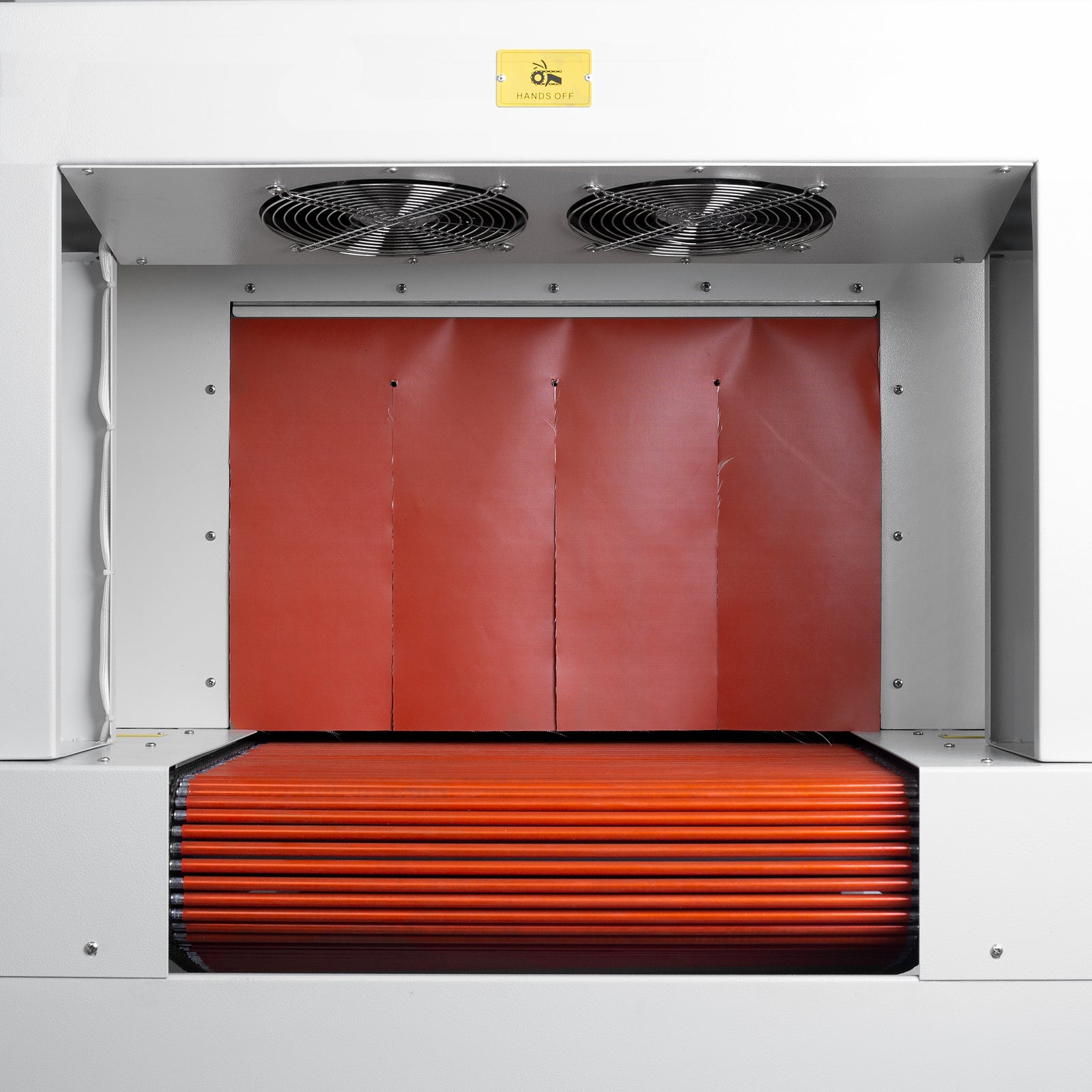 Close-up view of the exit of a heat shrink tunnel shows an orange heat-insulating curtain meant to preserve the tunnel's inner temperature. also shows 2 cooling fans positioned outside the tunnel as well as the the end of the roller conveyor.