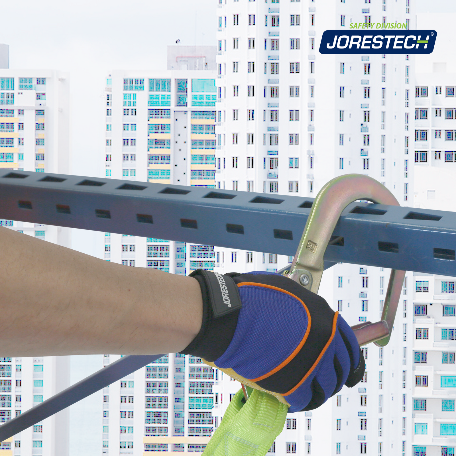 The hand of a worker securing one of the hooks of the JORESTECH shock absorbing lanyard on the rail of the scaffold