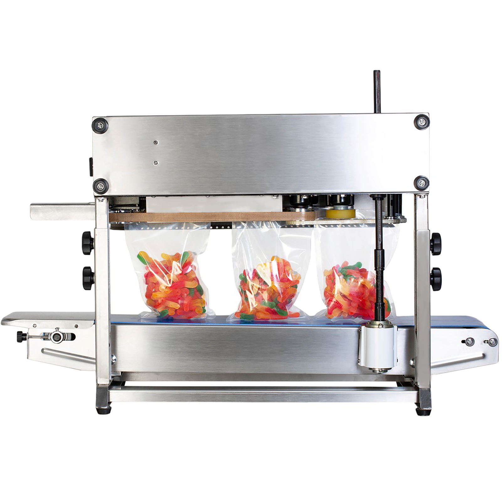 back view of the JORESTECH stainless steel continuous band sealing machine while it is sealing clear plastic bags filler with colored gummy worms. Machine is set for vertical applications..