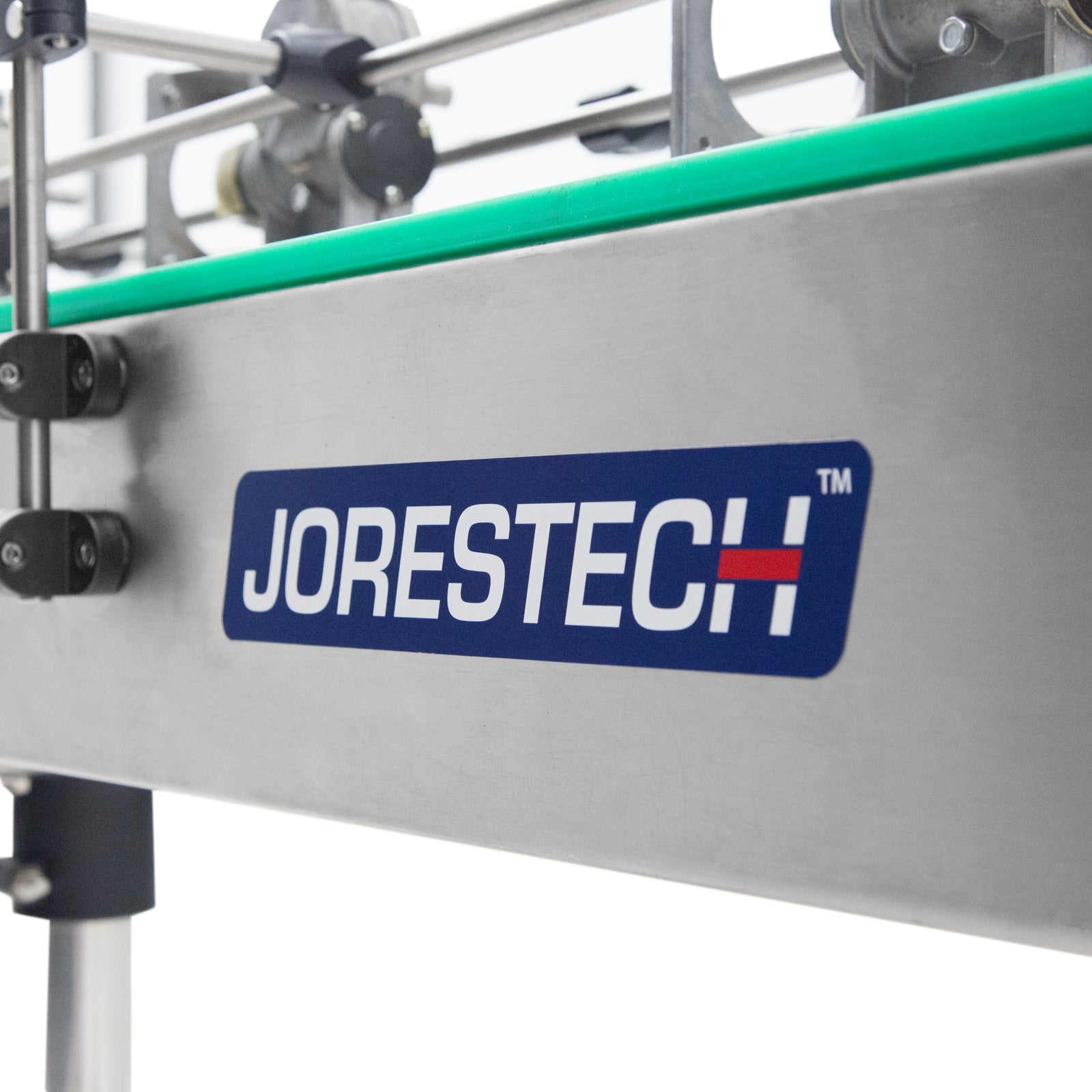 close up of blue Jorestech logo on stainless steel motorized conveyor