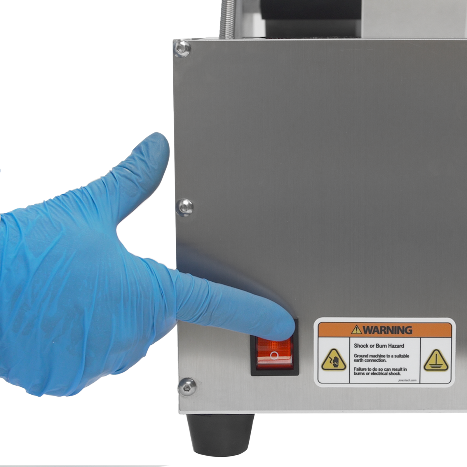 operator wearing blue gloves pressing a red switch to turn on the JORES TECHNOLOGIES® semi-automatic label applicator 