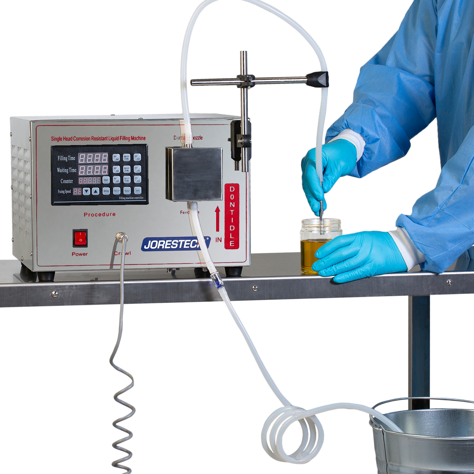 A person using the JORES TECHNOLOGIES® semi automatic liquid filler to fill a clear plastic bottle with an amber solution