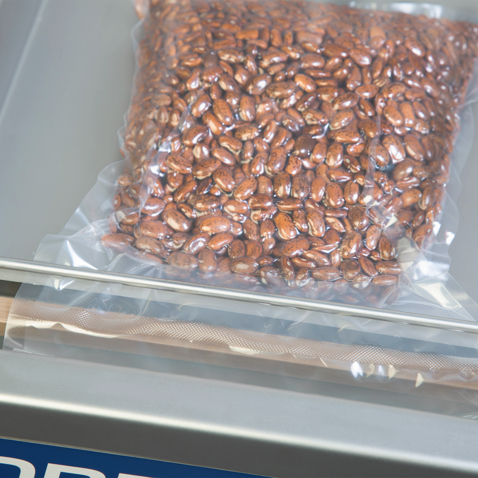 Detail a sealable vacuumed bag with red bean after using the stainless steel tabletop commercial chamber vacuum sealer with one seal bar. The seal of the vacuumed bag can be appreciated as well as the position on the sealing bar