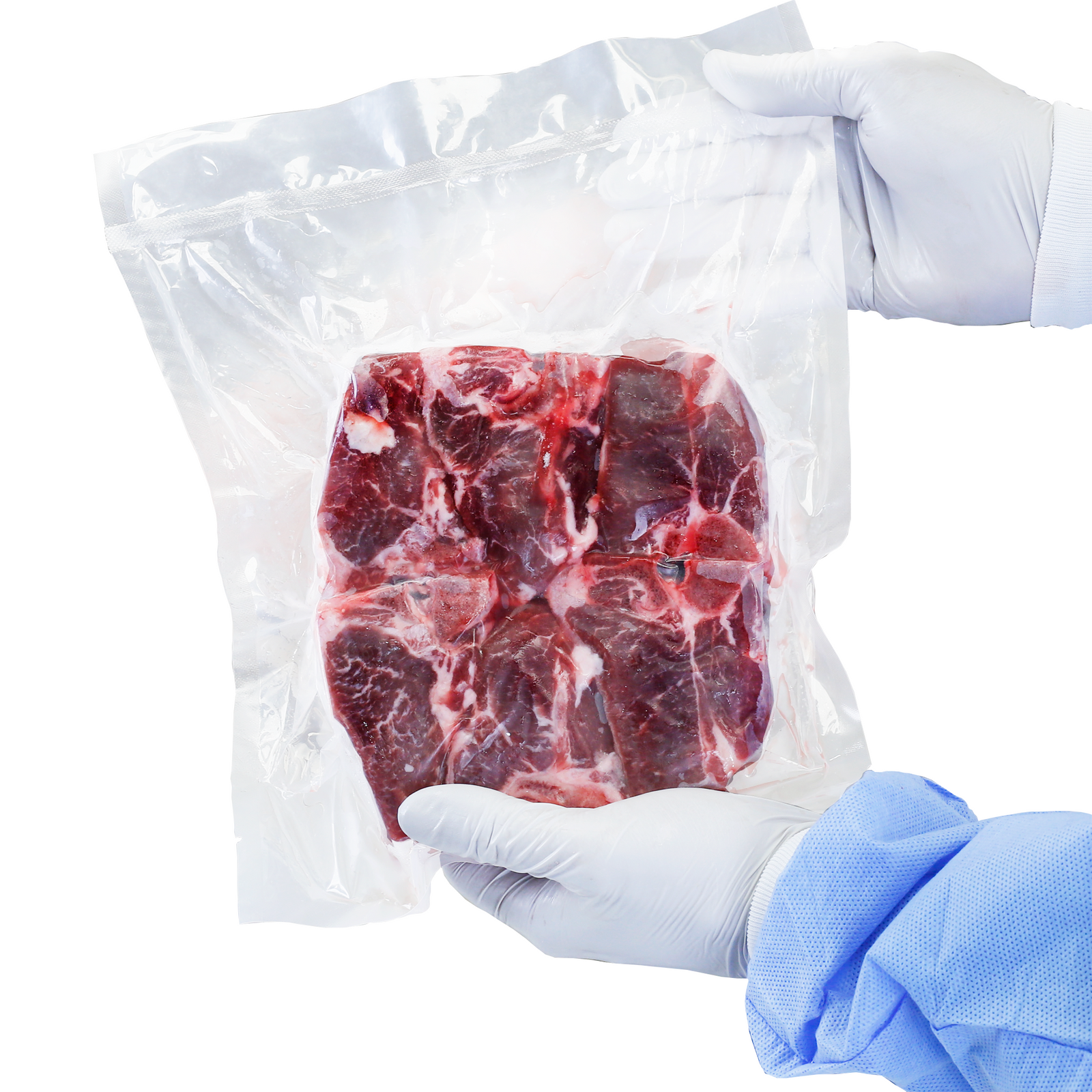 A freshly packaged vacuum bag containing red meat inside. A man wearing latex gloves is holding the package up to the camera. 