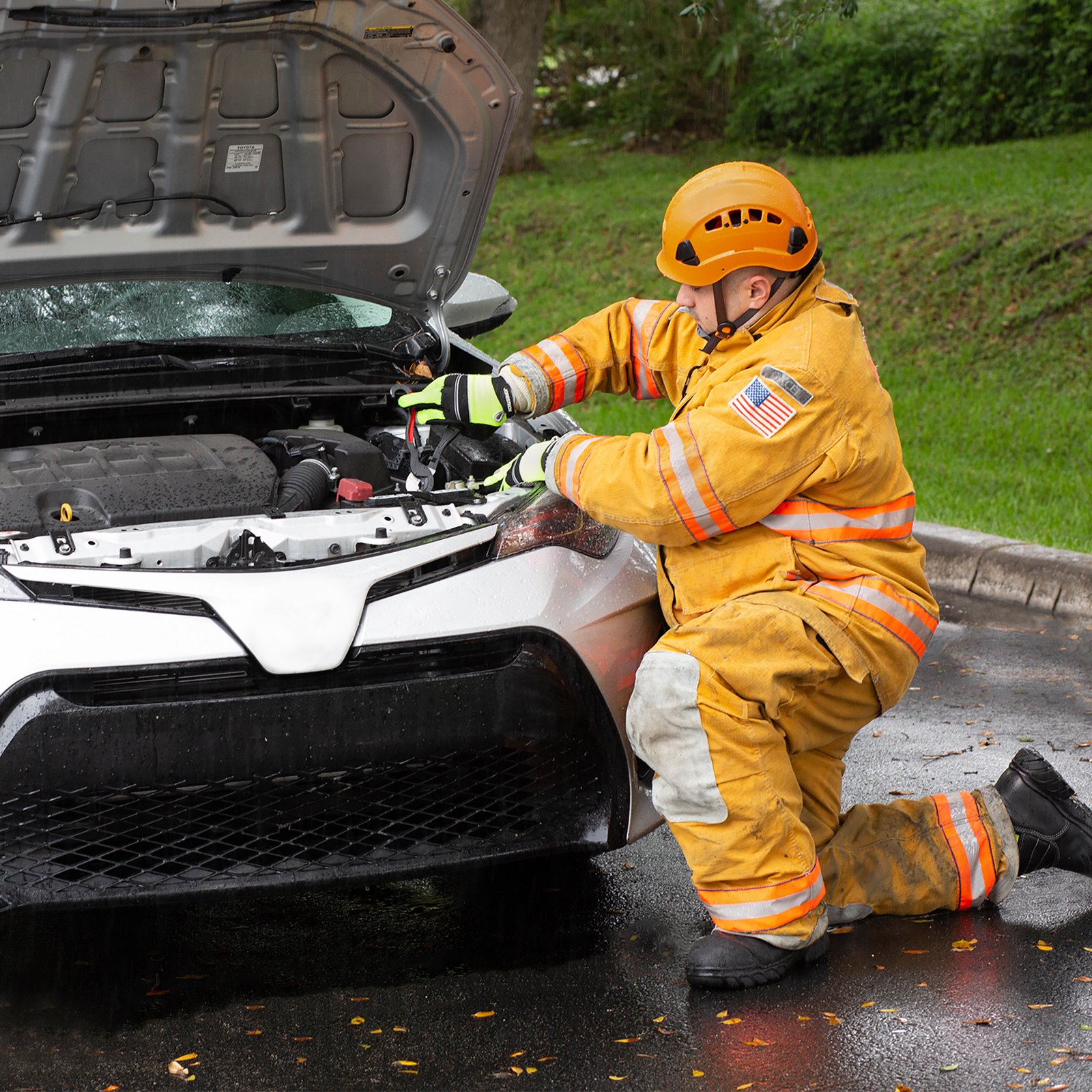 Mechanic fixing the motor of a car wearing the Jorestech orange ventilated hard hat with adjustable 6 point suspension