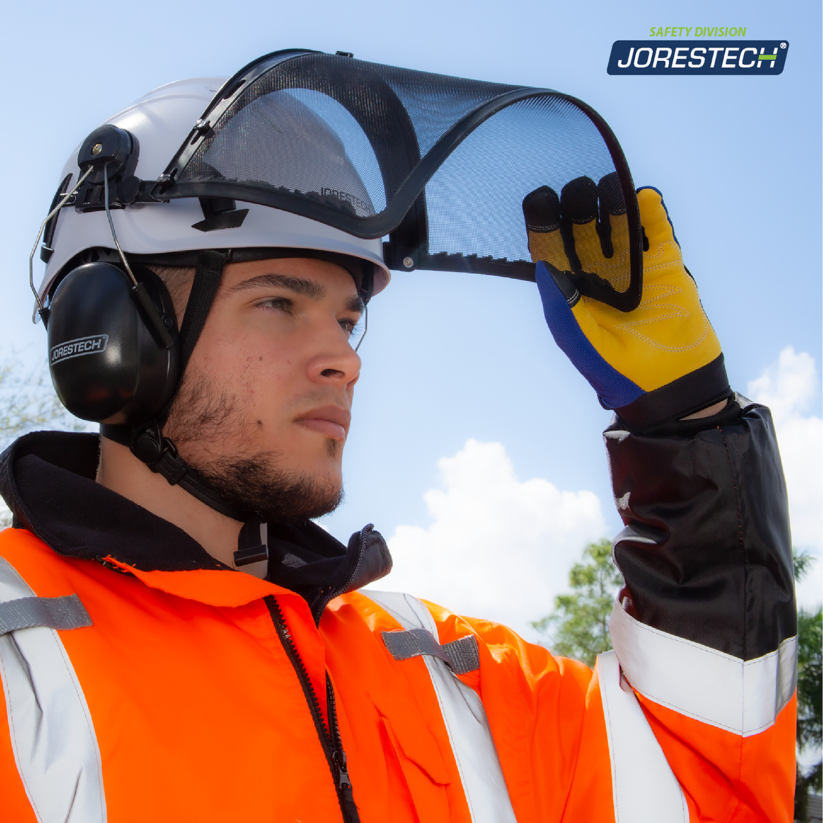 A man wearing the white jorestech ventilated safety hard hat with chin strap, the iron mesh face shield and earmuff attachments. He is pulling the face shield up showing how it pivots easily out of the way