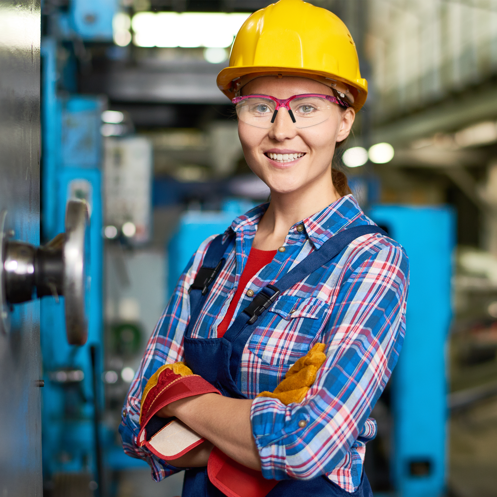 A young lady wearing PPE and the Jorestech wrap around safety glasses with flexible rubber temple tips in a manufacturer setting